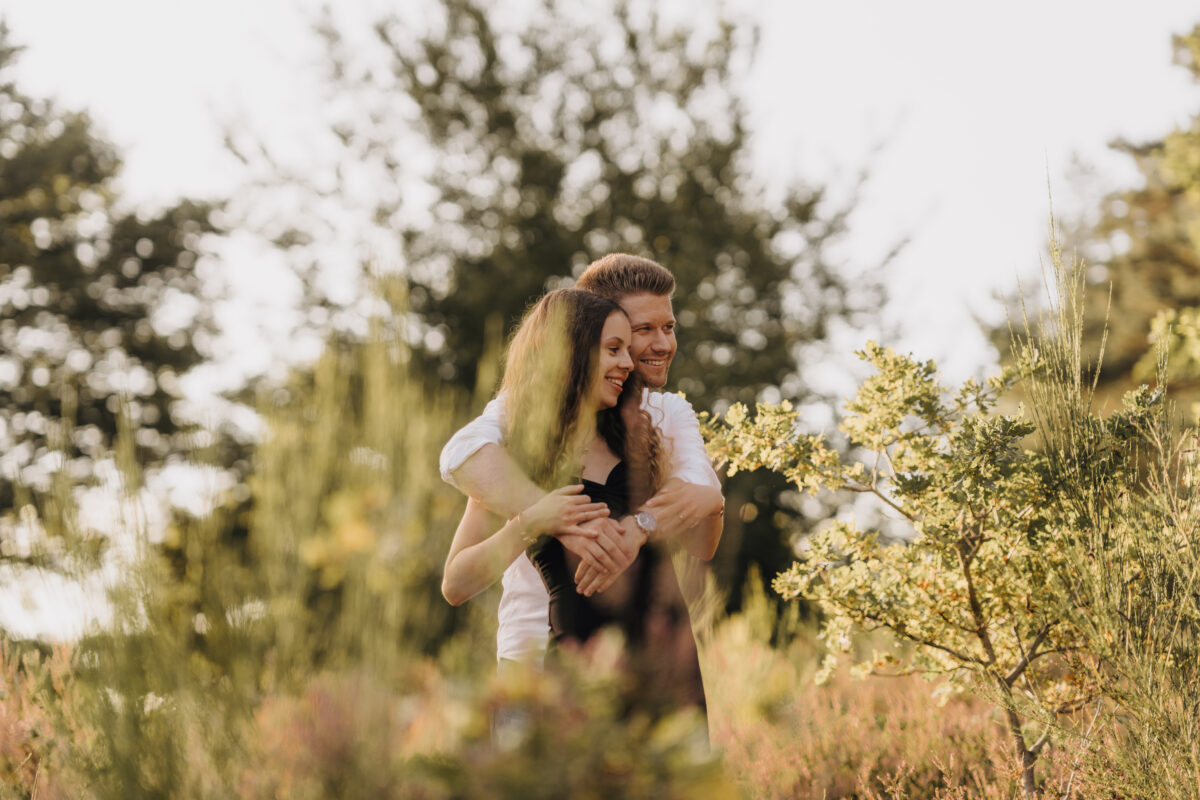 Er umarmt sie von hinten im Feld