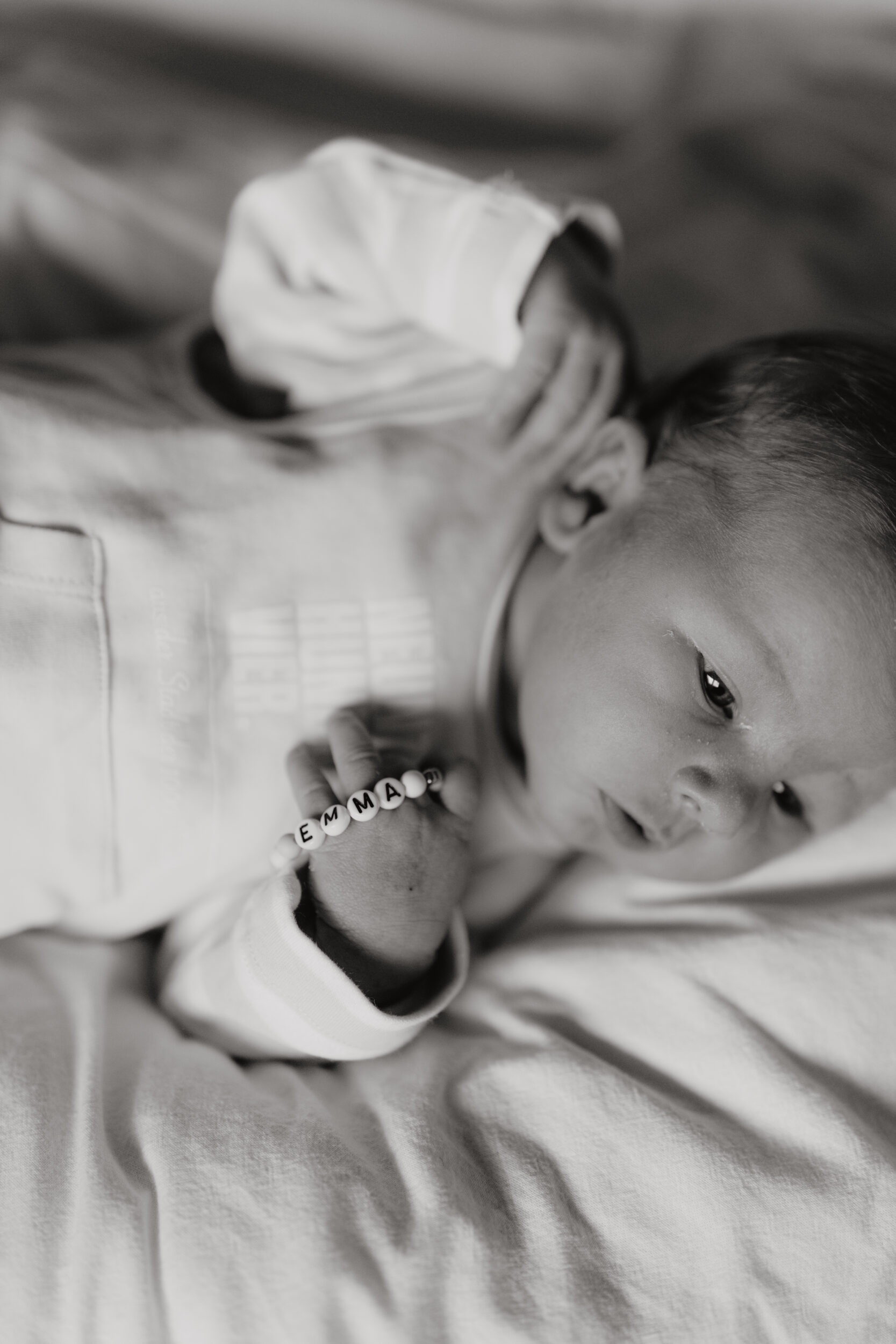 Newborn Portfolio Baby mit Namensarmband in der Hand