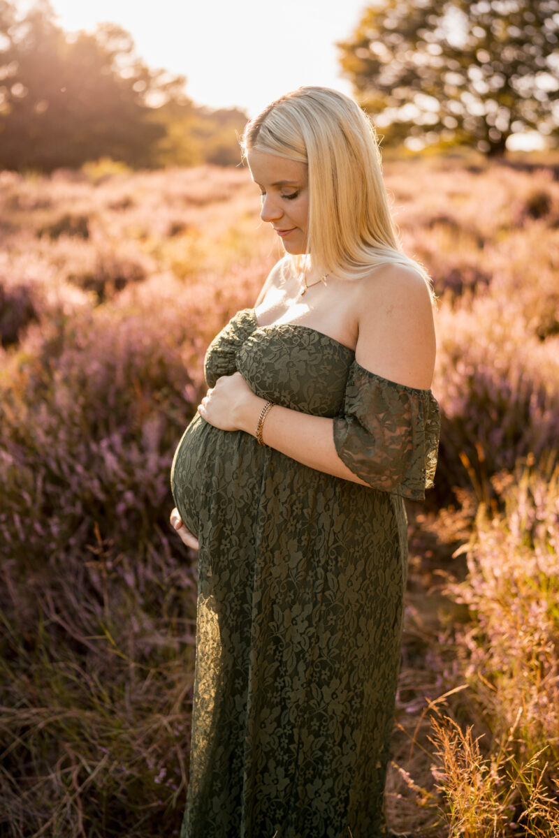 Babybauch Fotografie Portfolio schwangere Frau posiert in einem grünen Kleid in der Natur