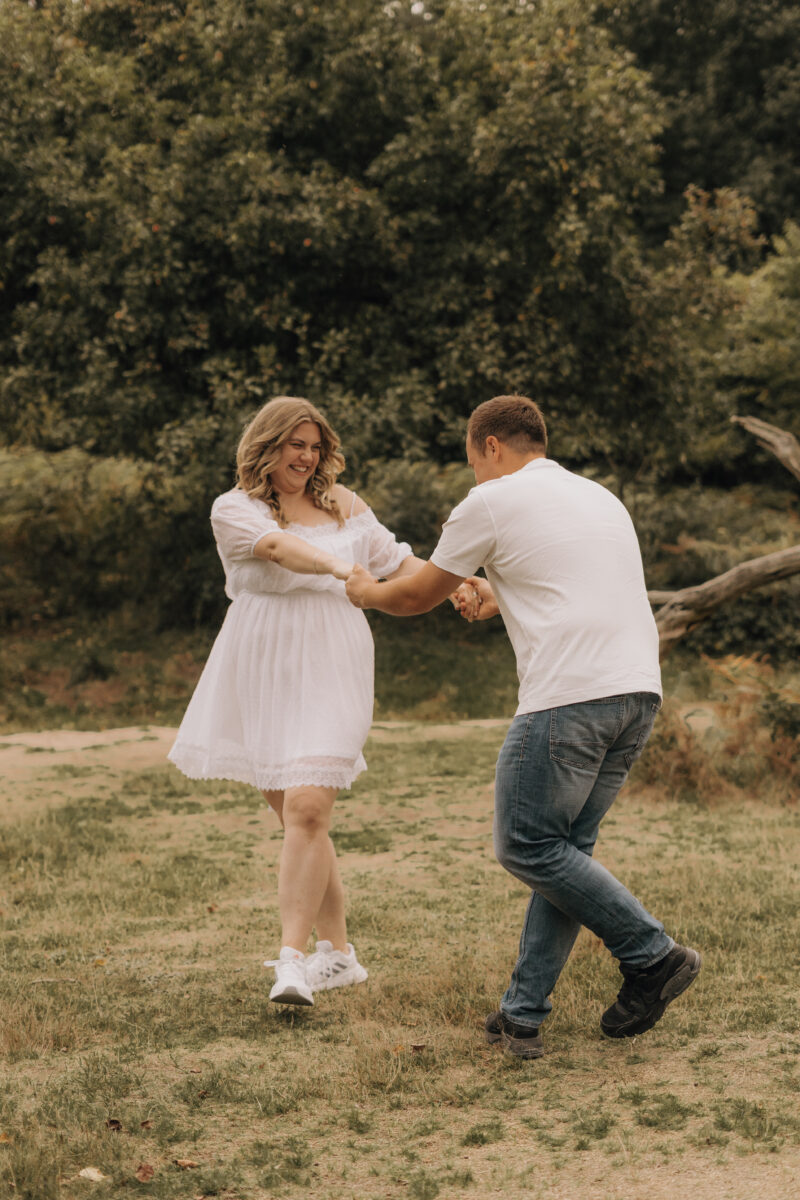 Paar tanzt auf einer Wiese und lacht