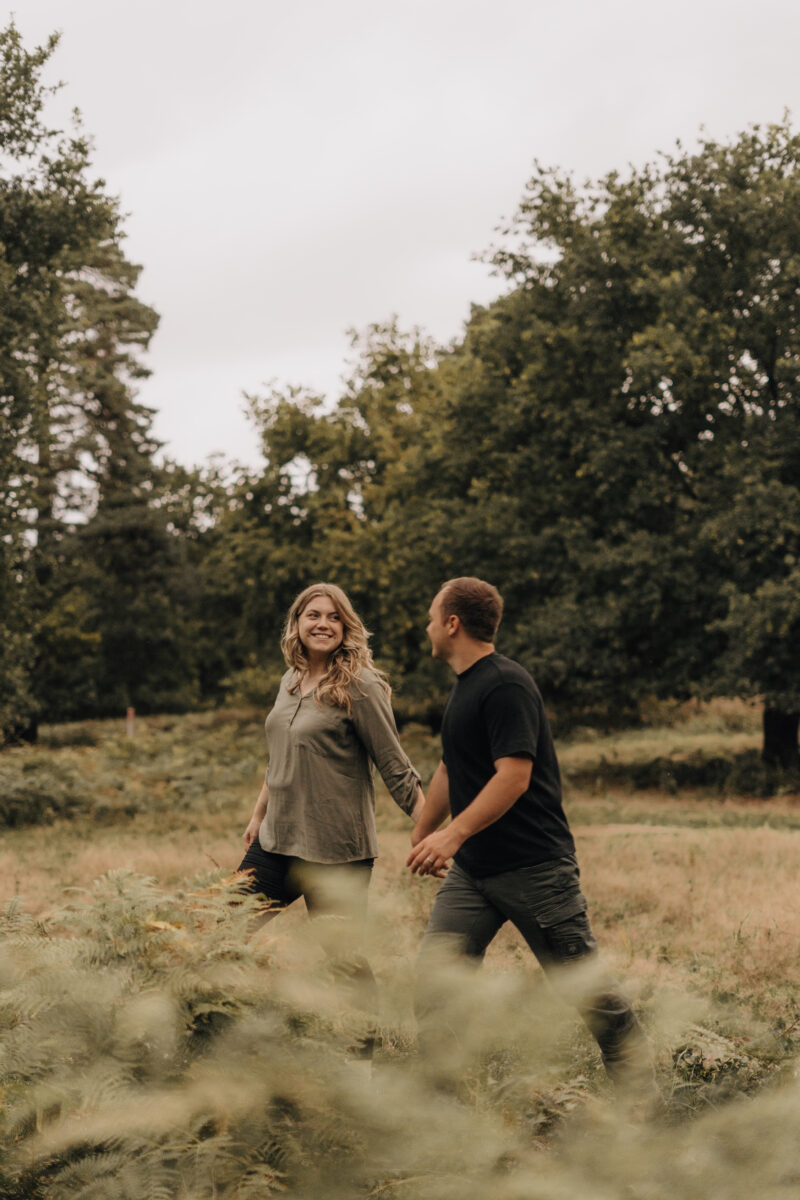 Paar läuft lachend durchs Feld zusammen