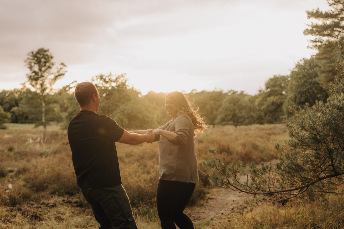 Paar dreht Pirouetten im Sonnenuntergang und lacht dabei