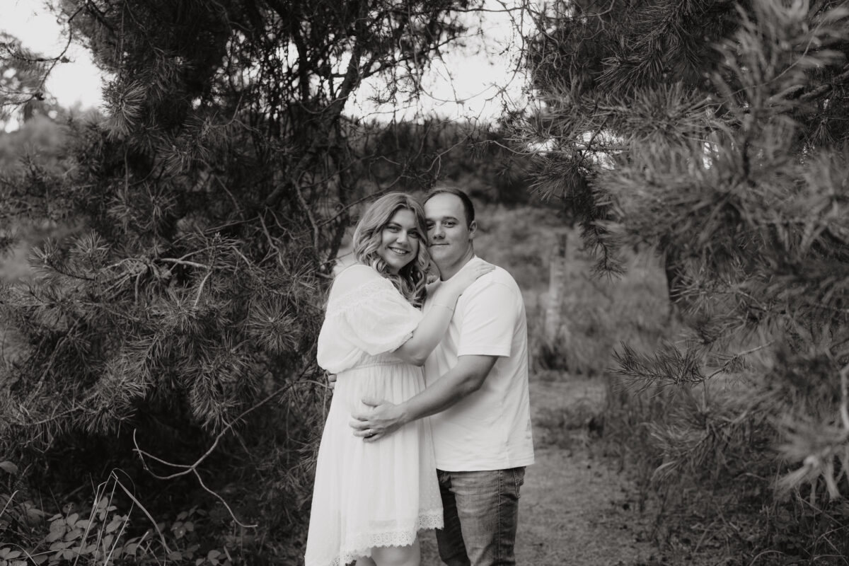 Paar umarmt sich und schaut in die Kamera, fotografiert in Schwarz-Weiß