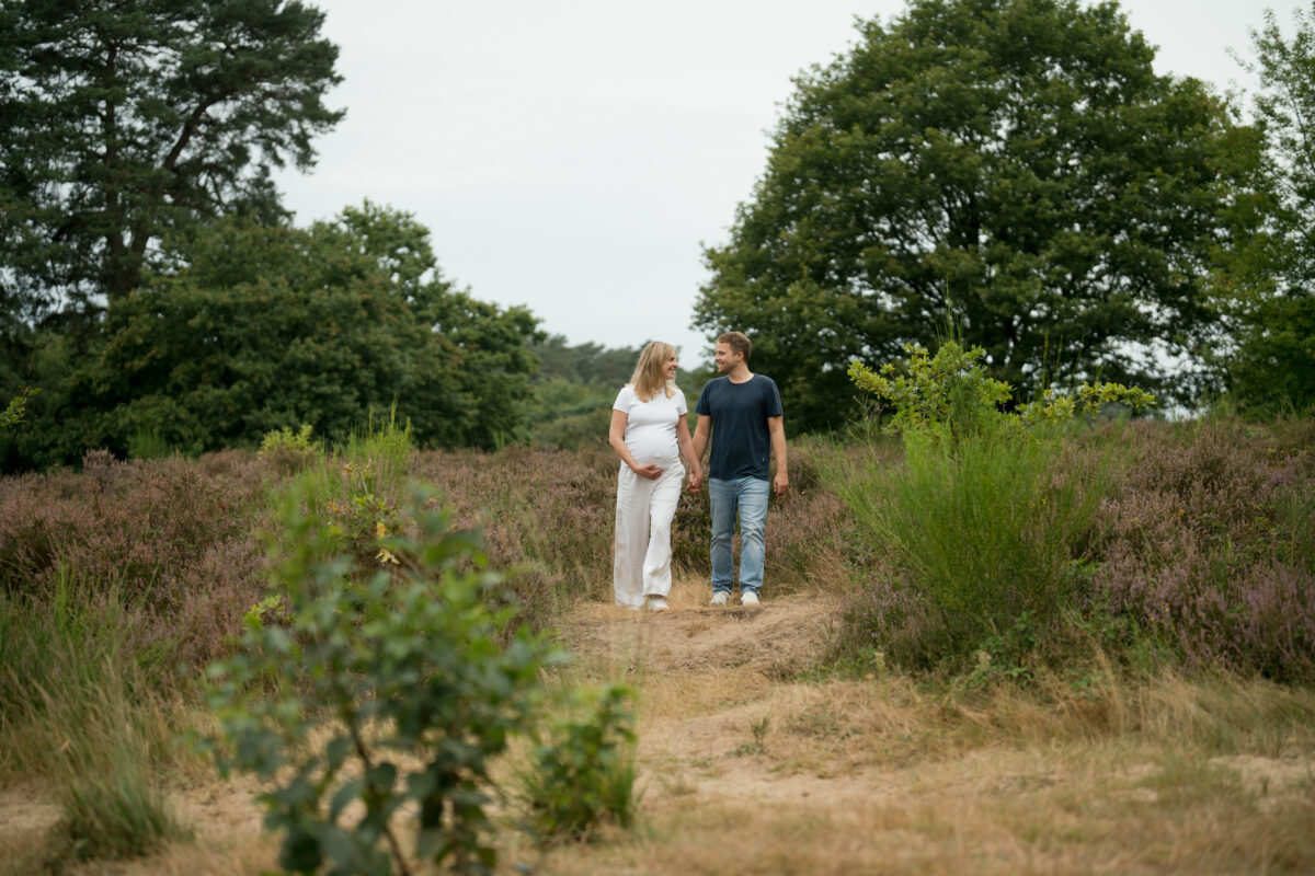 Babybauch Fotografie Portfolio werdendes Elternpaar geht Feldweg entlang