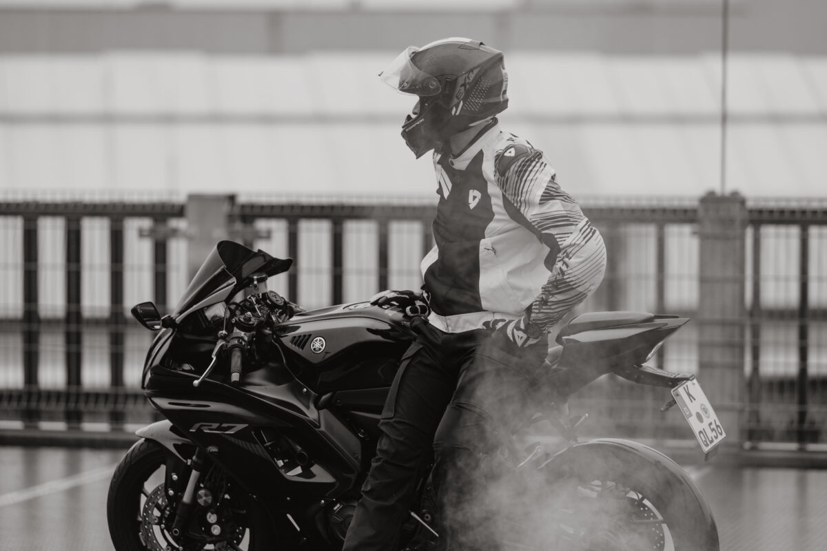 Schwarz-Weiß Portraitfoto eines Mannes, auf dem Motorrad sitzend