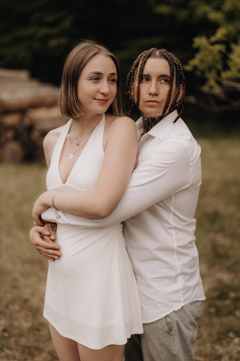 Sie wird von hinten umarmt und lächelt