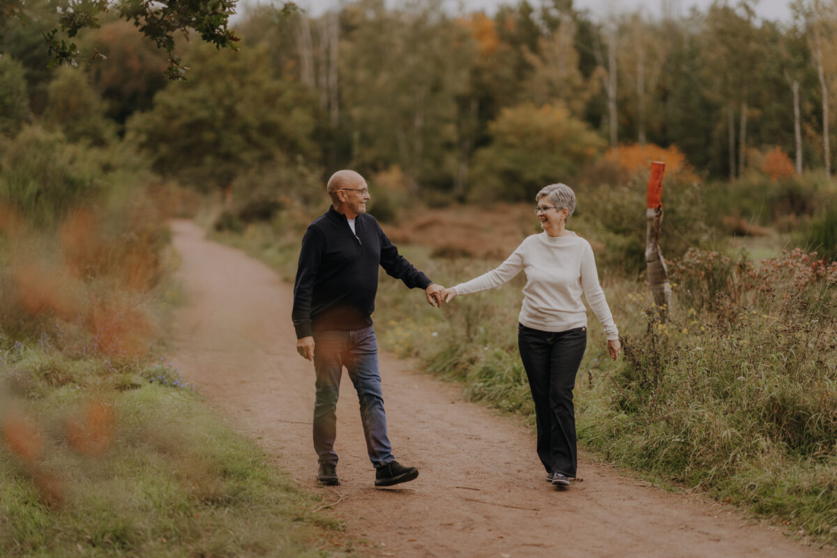 Paar schlendert Händchen haltend auf die Kamera zu