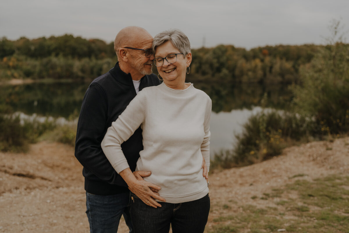 Sie wird von hinten umarmt und lächelt