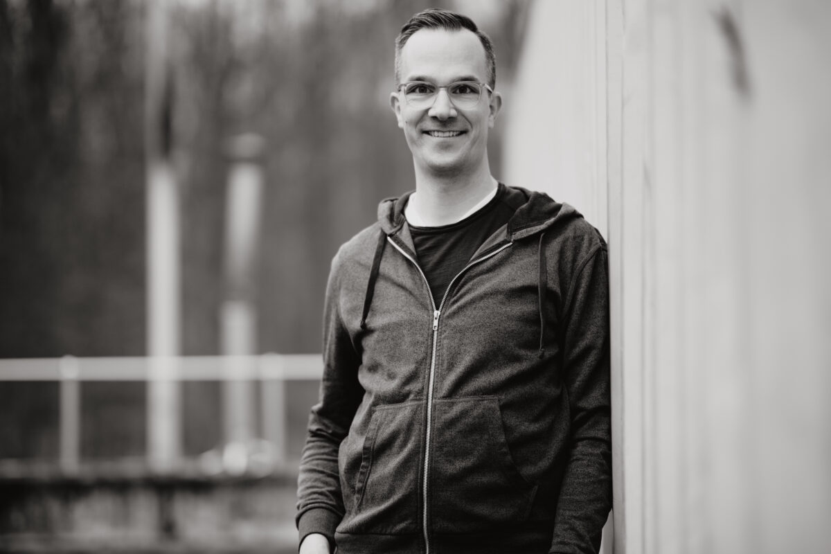 Schwarz-Weiß Portraitfoto eines Mannes, freundlicher Blick zur Kamera