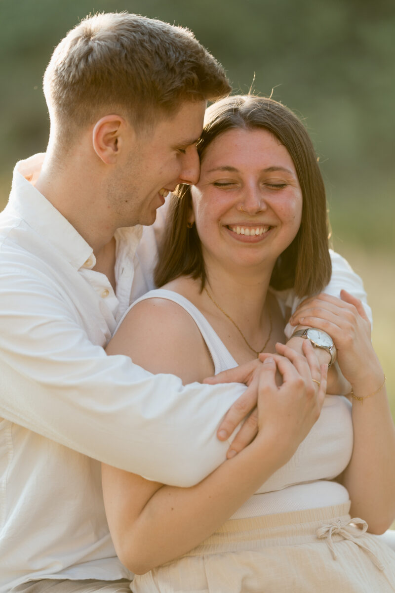 Sie wird von hinten umarmt und lacht
