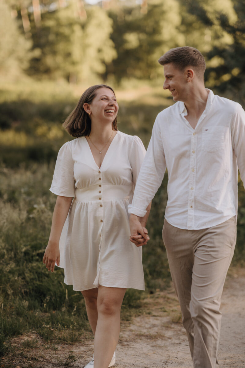 Paar schlendert auf die Kamera zu und lacht