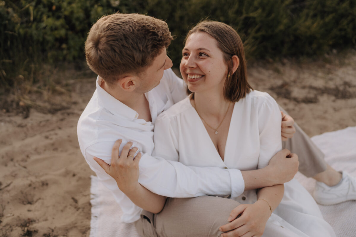 Paar sitzt Arm in Arm und lacht