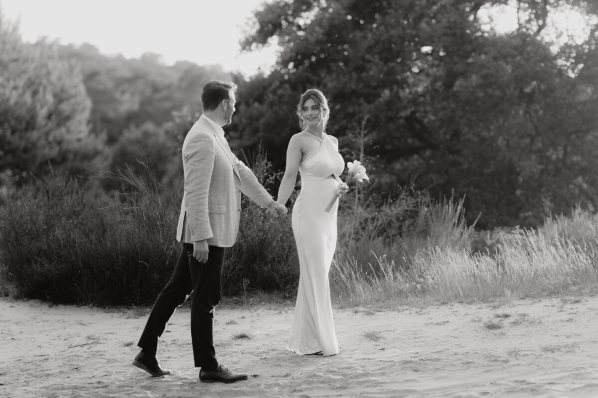 Paar schlendert Händchen haltend über einen Weg