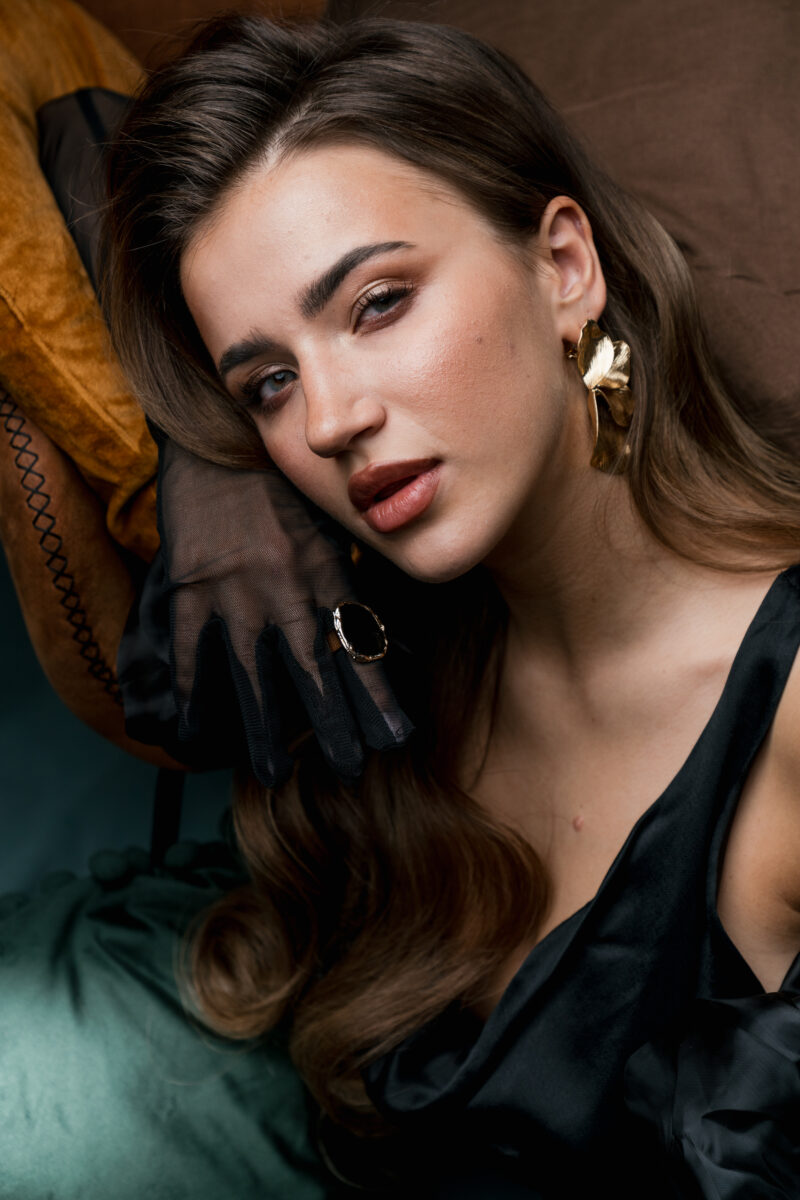 Kreatives Portraitfoto einer Frau mit starkem Make up, schaut verwegen in die Kamera