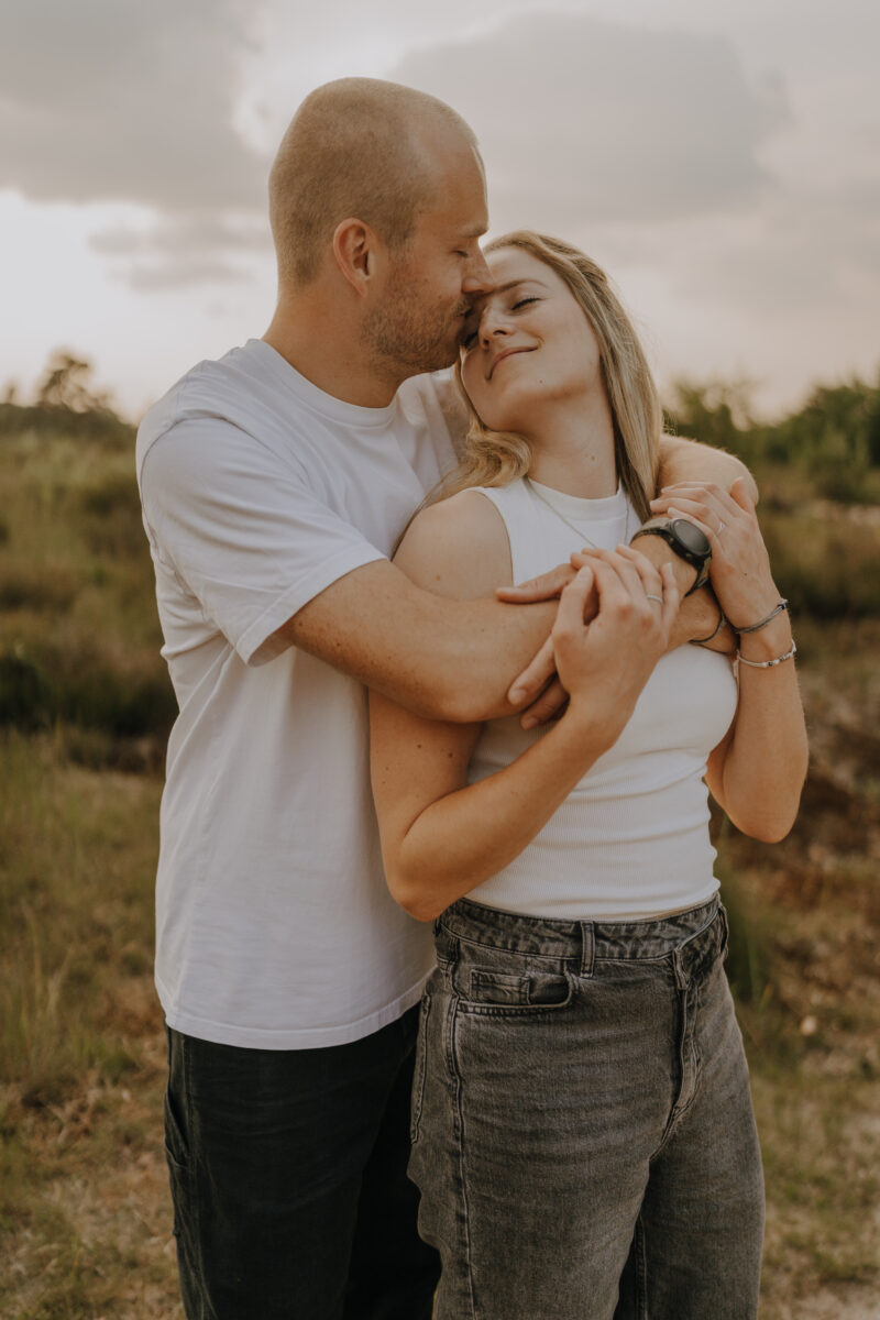 Sie wird von hinten umarmt und schaut ihn an