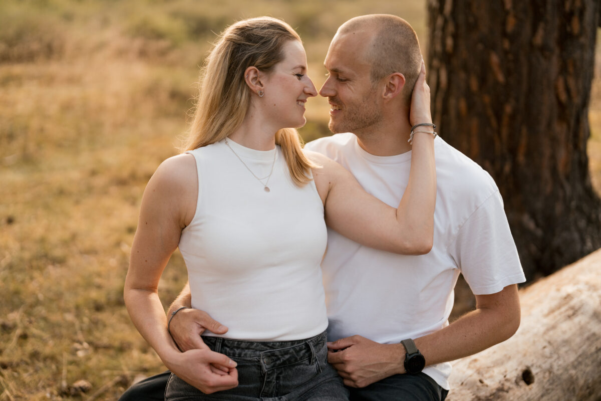 Paar schaut sich in die Augen und setzt zum Kuss an in der Abendsonne