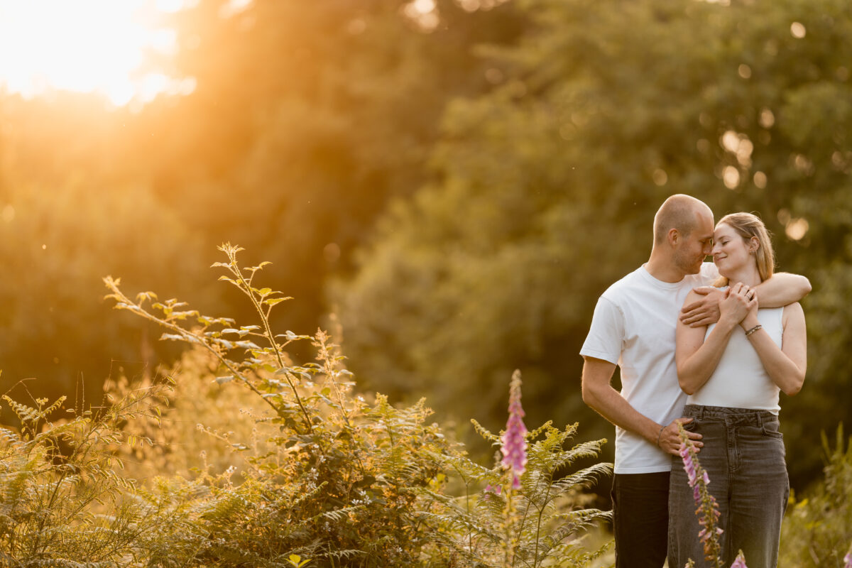 Paar umarmt sich in der Abendsonne im Wald