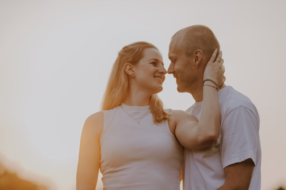 Paar schaut sich lächelnd an und setzt zum Kuss an