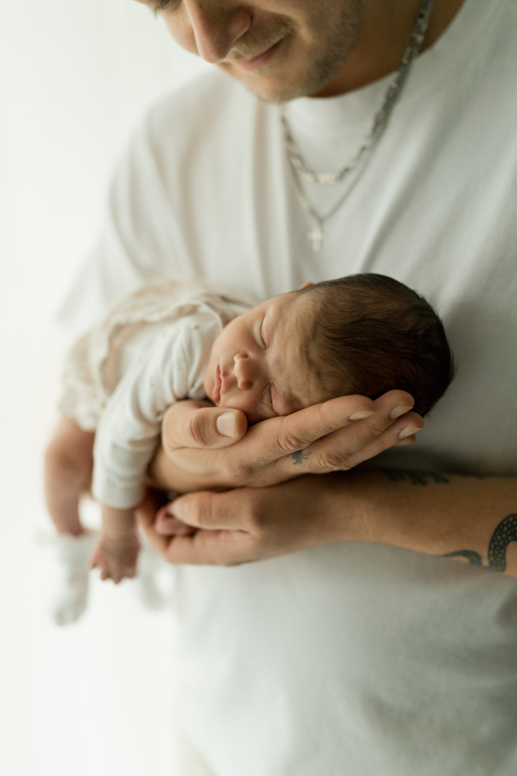 Newborn Portfolio Baby mit dem Bauch auf Papas Arm