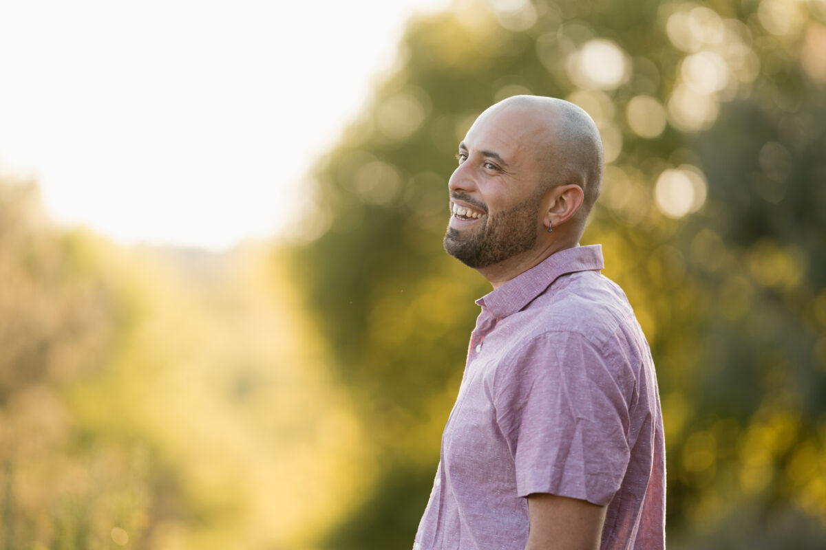 Portraitfoto eines Mannes, ausgelassen lachend im Sonnenuntergang