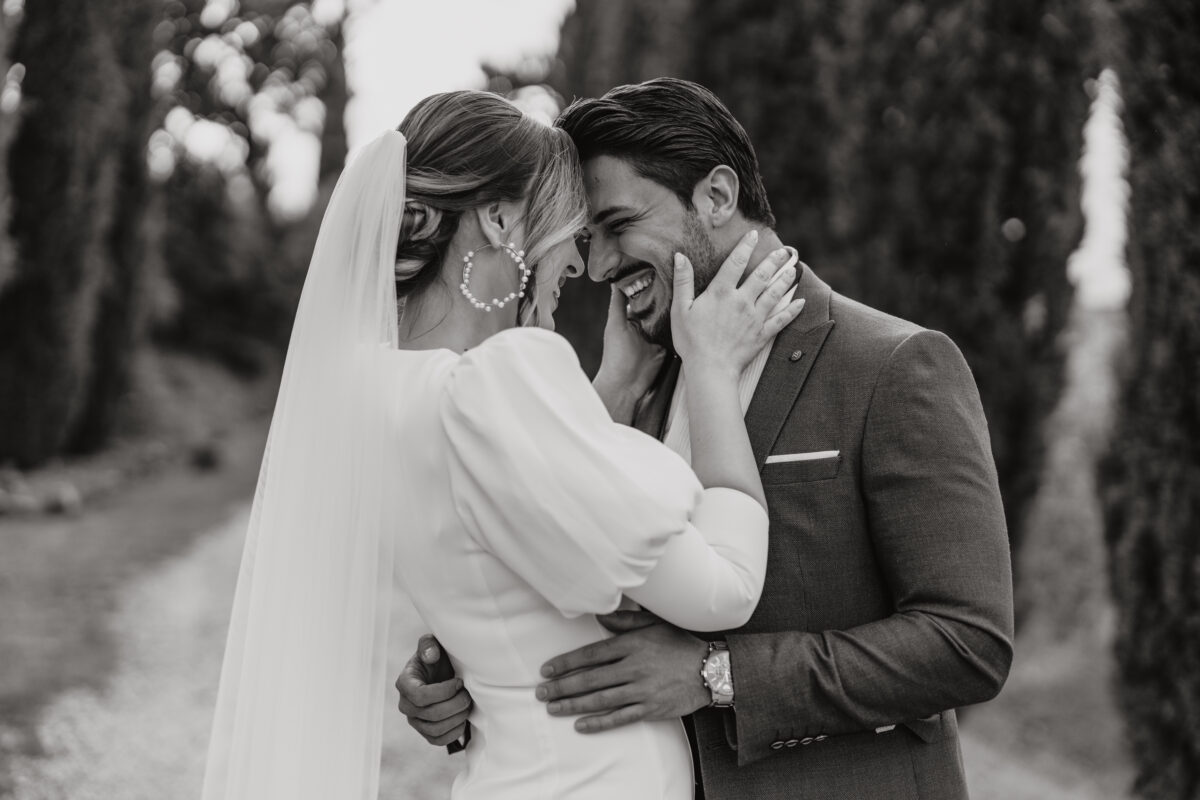 Destination Wedding Portfolio Hochzeitspaar umarmt sich lachend, schwarz-weiß