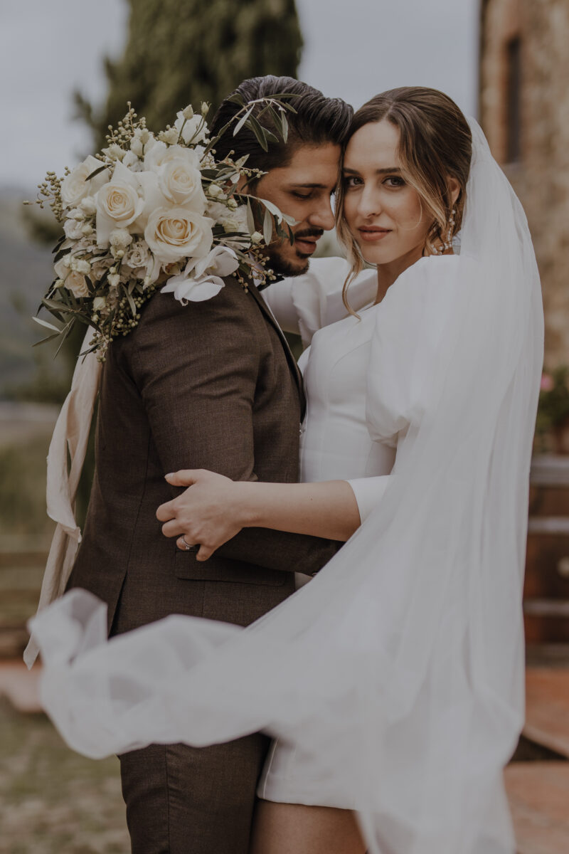 Destination Wedding Portfolio Hochzeitspaar umarmt sich vor verschwommenem Hintergrund