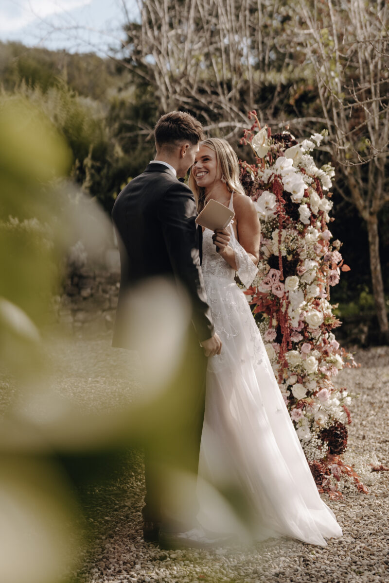 Destination Wedding Portfolio Hochzeitspaar posiert vor Blumenschmuck
