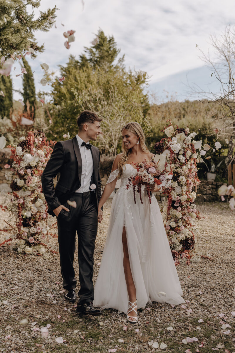 Destination Wedding Portfolio Hochzeitspaar posiert vor Blumenschmuck