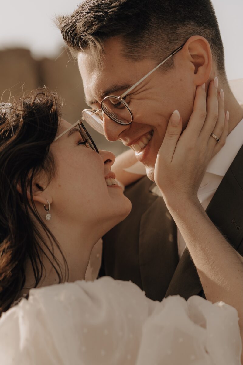 After Wedding Portfolio, Nahaufnahme. Braut und Bräutigam lächeln sich an. Die Braut hält das Gesicht mit ihrer rechten Hand