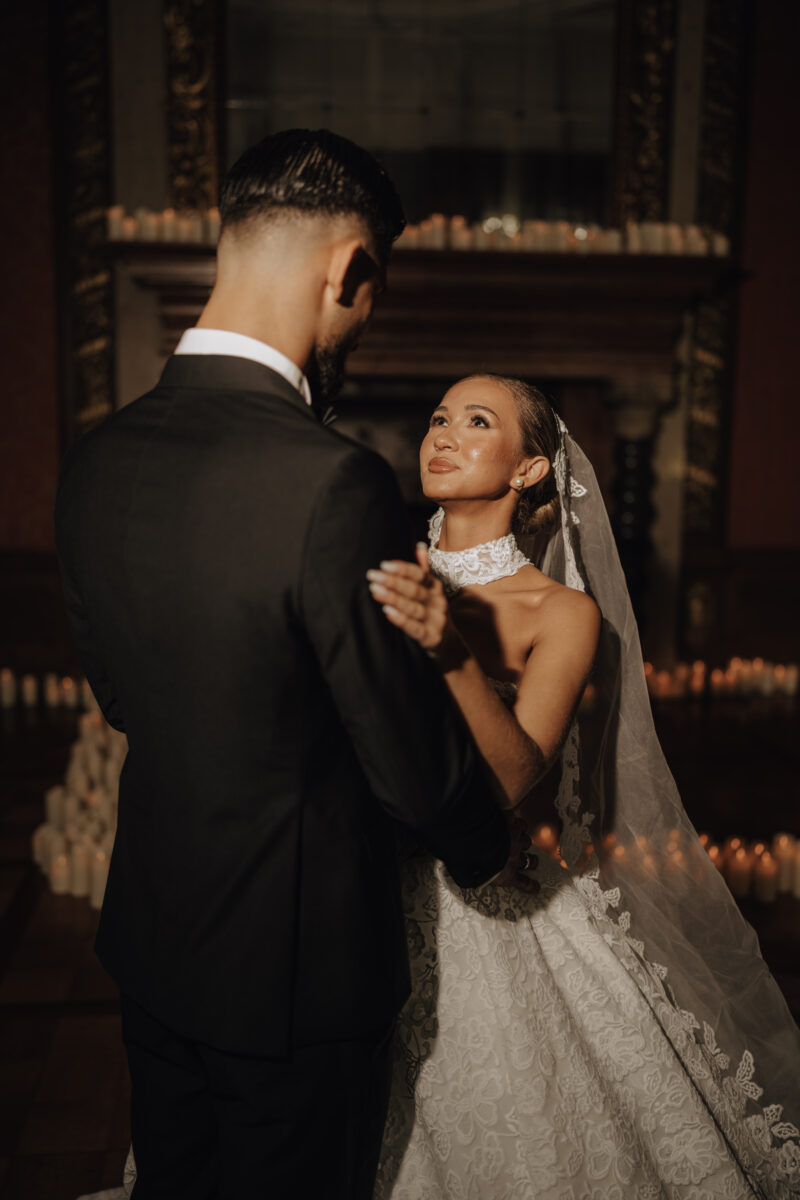 Hochzeitsportfolio, Braut und Bräutigam halten sich in den Armen. Sie schaut lächelnd zu ihm hoch und schaut ihn verliebt an.