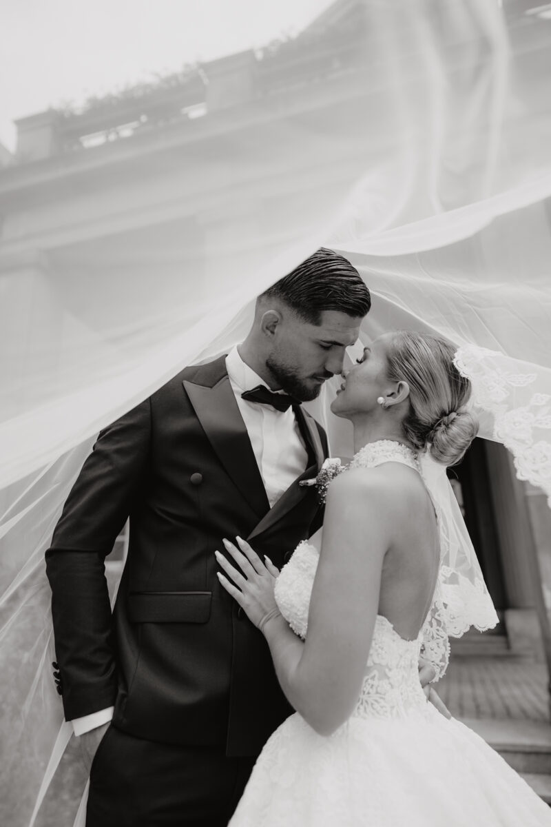 Hochzeitsportfolio, Romantisches Brautpaar unter Schleier beim Hochzeitsshooting, sie halten Nase an Nase und haben beide die Augen geschlossen | Hochzeitsfotografie Köln