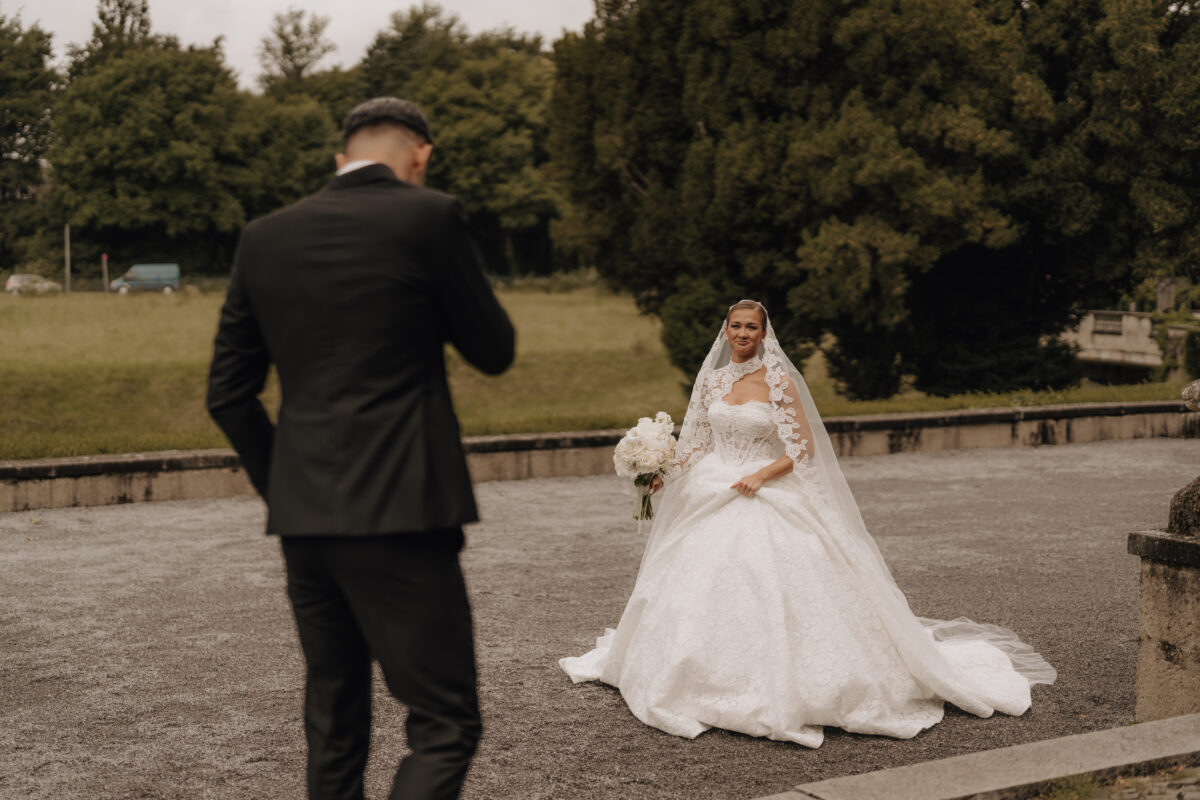 Hochzeitsportfolio, First Look vom Bräutigam auf die Braut. Er geht auf sie zu, sie wartet im Hintergrund.