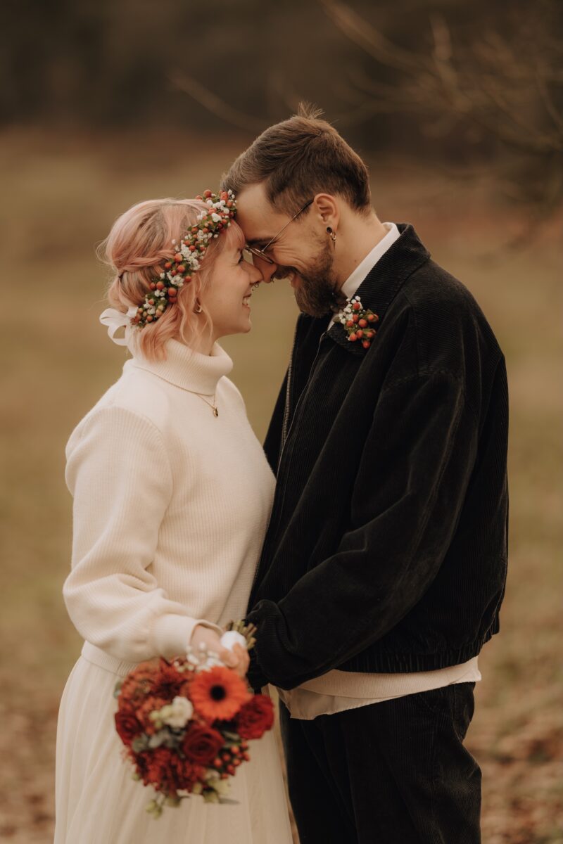 After Wedding, Braut und Bräutigam lächeln sich gegenseitig an und ihre Nasenspitzen berühren sich. Er hält ihre Hände.