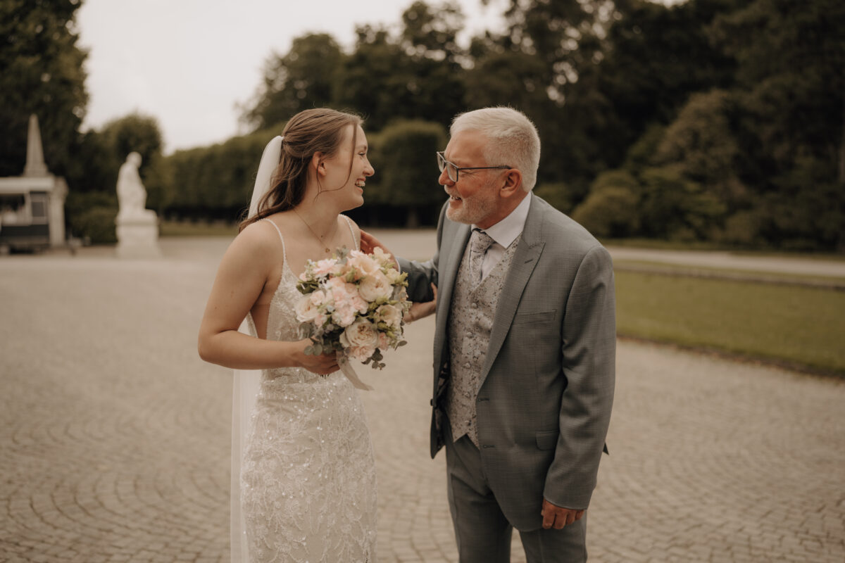 Hochzeitsportfolio, Braut mit ihrem Vater bei einem emotionalen Moment der Hochzeit, beide lachen sich an | Hochzeitsreportage NRW