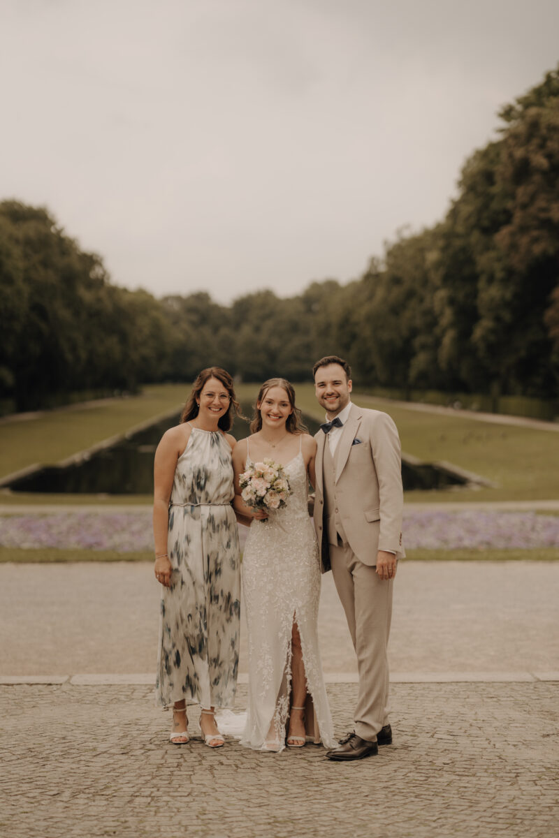 Hochzeitsportfolio, Gruppenfoto Brautpaar mit Freundin im Schlossgarten | Hochzeitsfotografie NRW