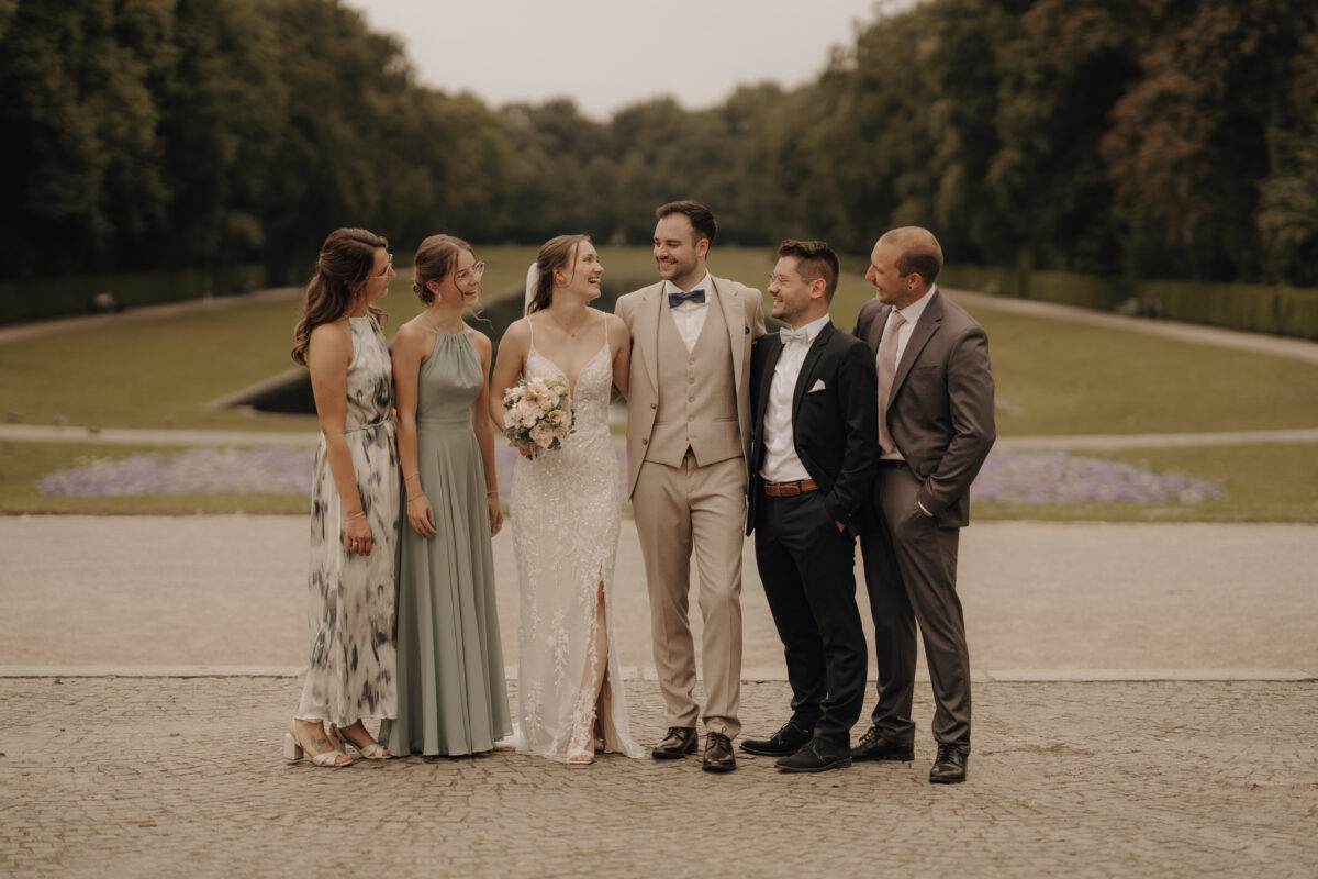 Hochzeitsportfolio, Hochzeitsgesellschaft mit Brautpaar bei Gruppenfoto im Schlosspark | Hochzeitsreportage NRW