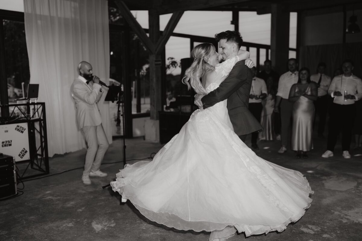 Hochzeitsportfolio, Braut und Bräutigam tanzen. Der Bräutigam hebt die Braut hoch und wirbelt sie herum.