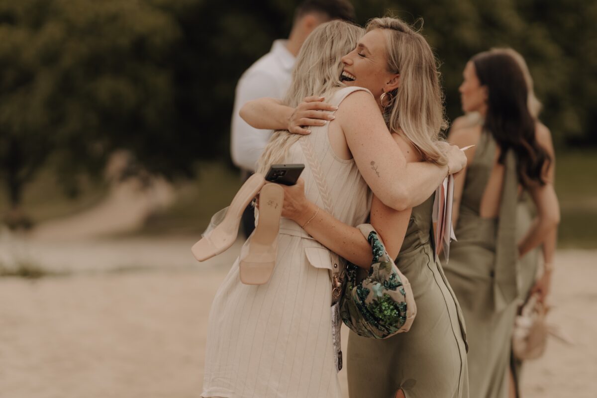 Hochzeitsportfolio, Farbaufnahme zwei Frauen umarmen sich innig und lachen