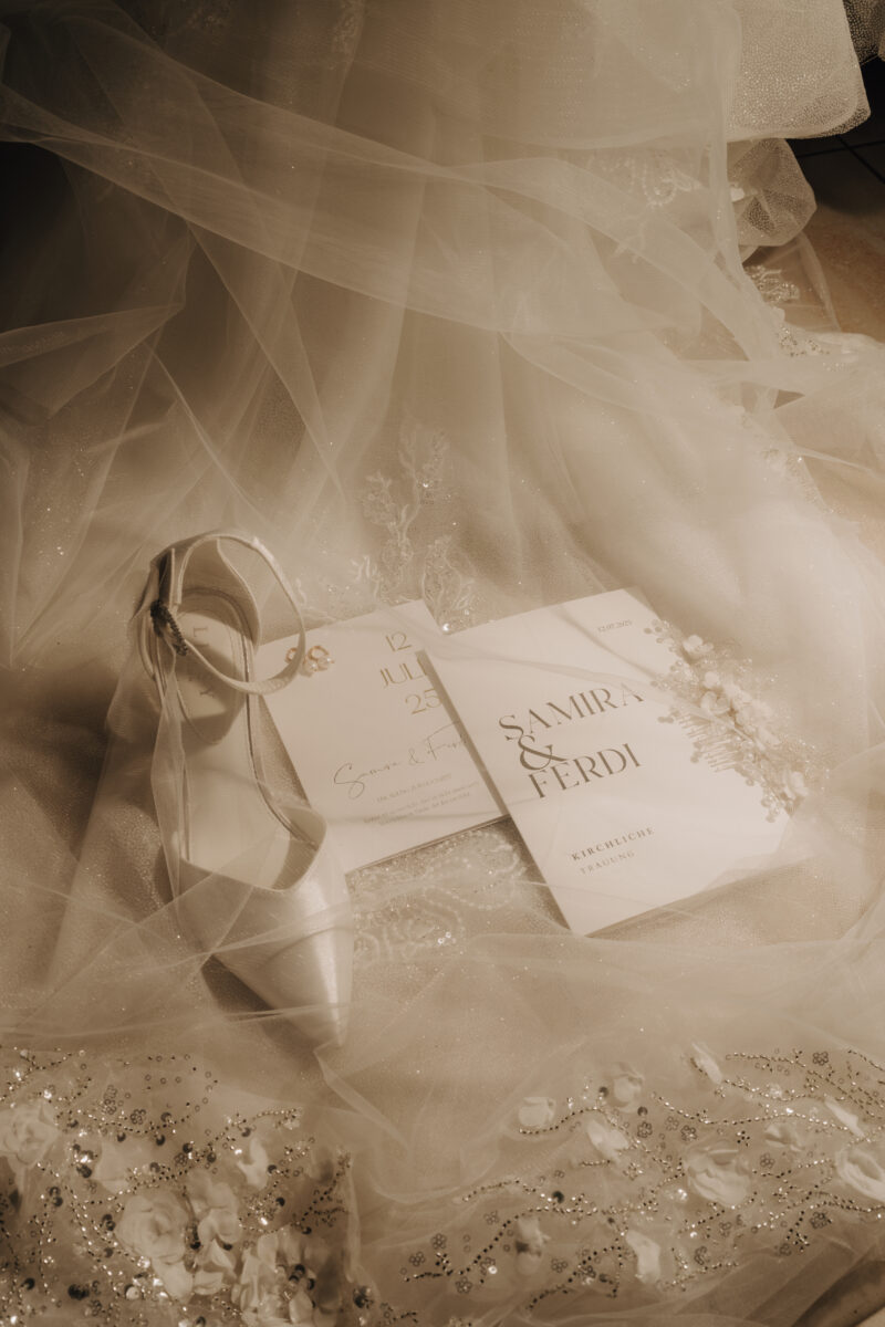 Hochzeitsportfolio, Flatlay Hochzeitsdetails mit Eheringen und Einladung auf Brautschleier | Hochzeitsfotografie Köln