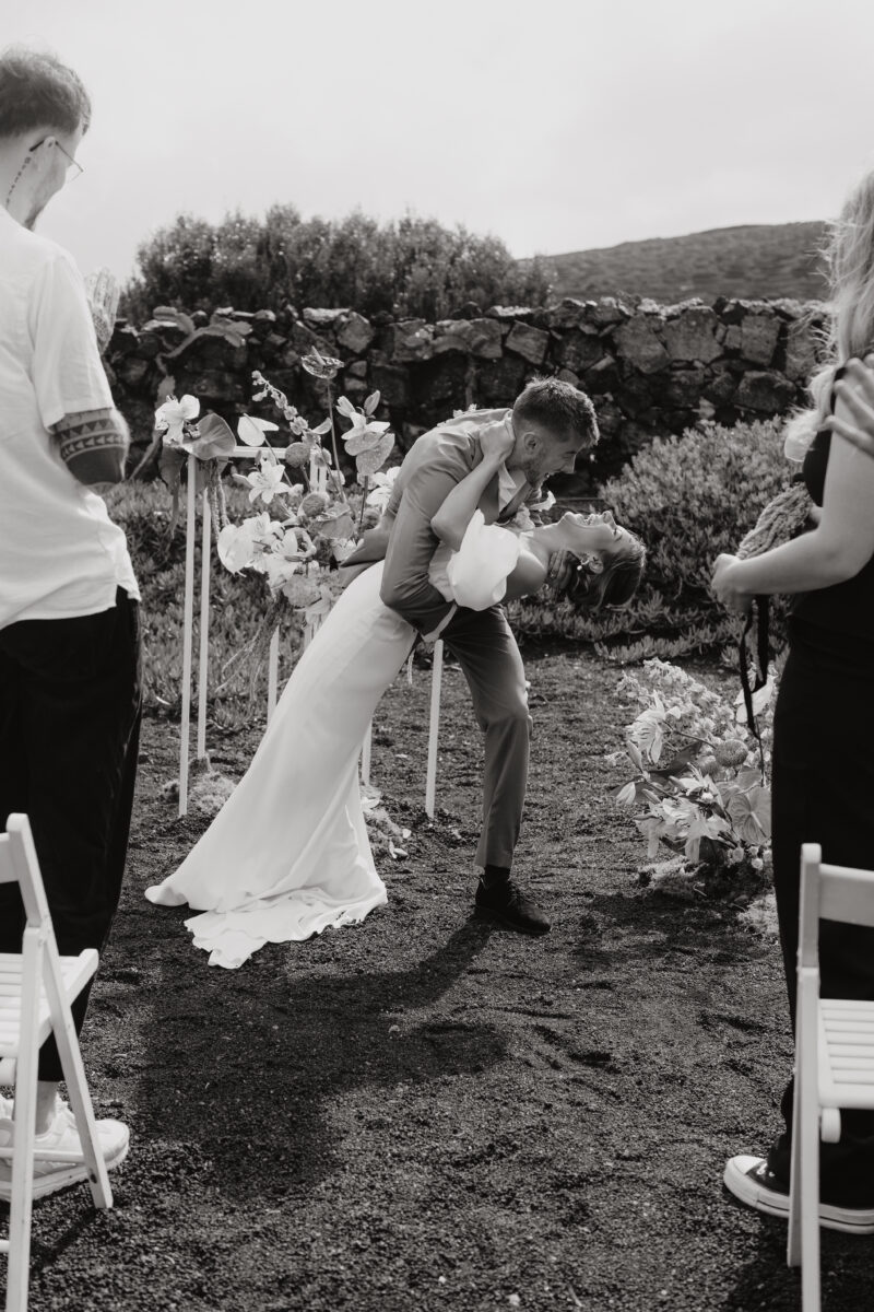 Destination Wedding Portfolio Hochzeitspaar posiert vor Blumensträußen, schwarz-weiß