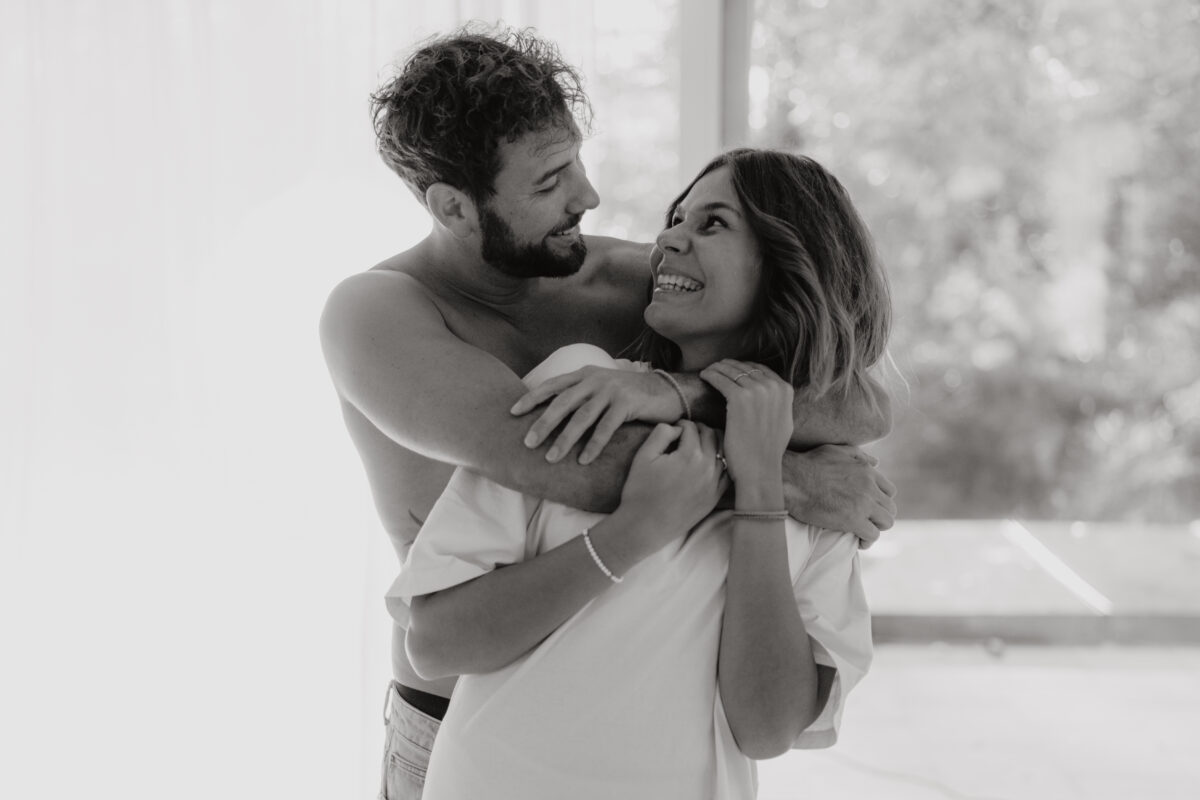 Akt- und Erotikfotografie Portfolio, Paar hält sich im Arm und lacht sich an, schwarz-weiß