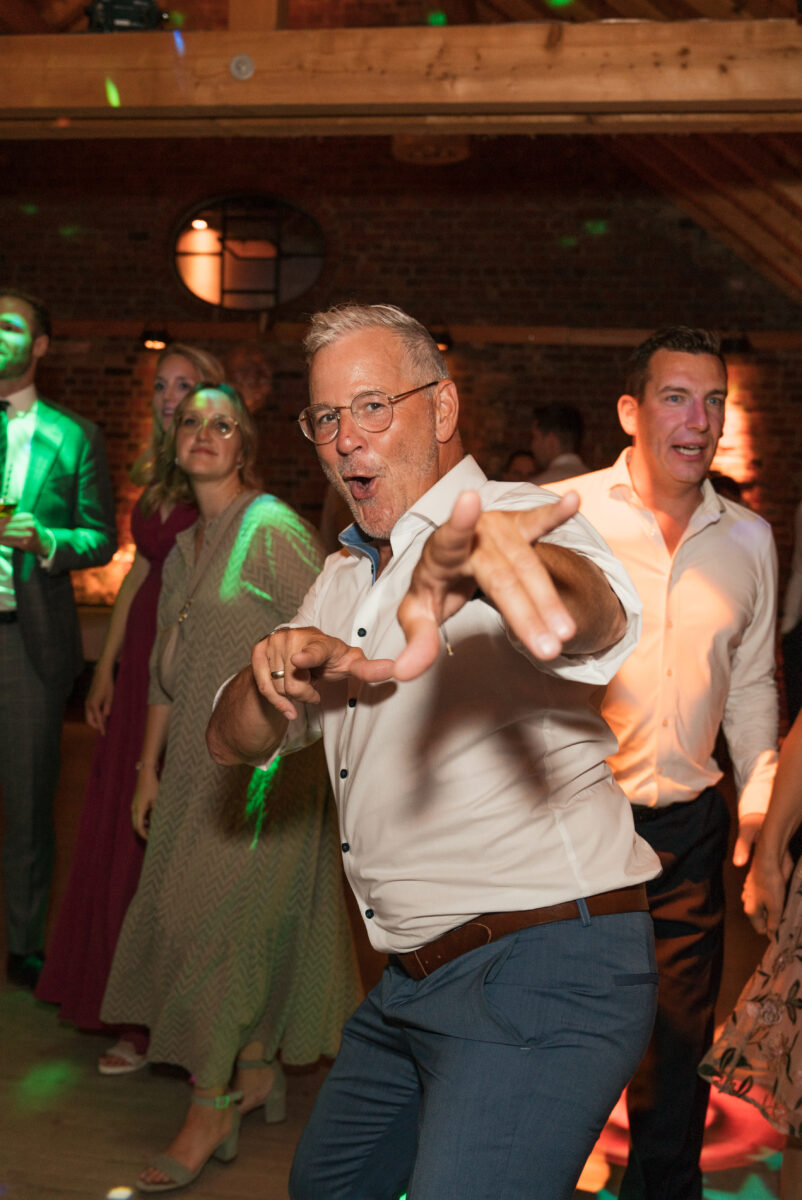 Hochzeitsportfolio, Partygast jubelt und zeigt in die Kamera