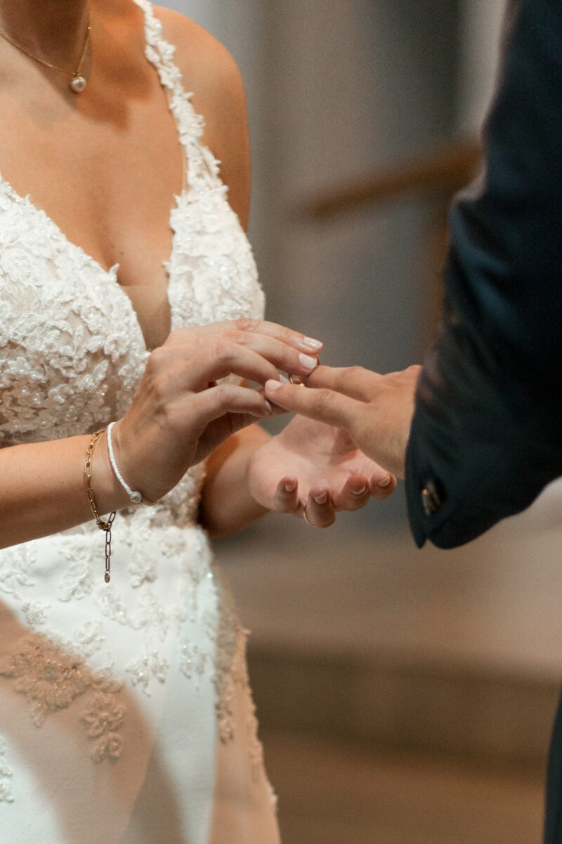 Hochzeitsportfolio, Ringtausch von Hochzeitspaar, Braut steckt dem Bräutigam den Ring an