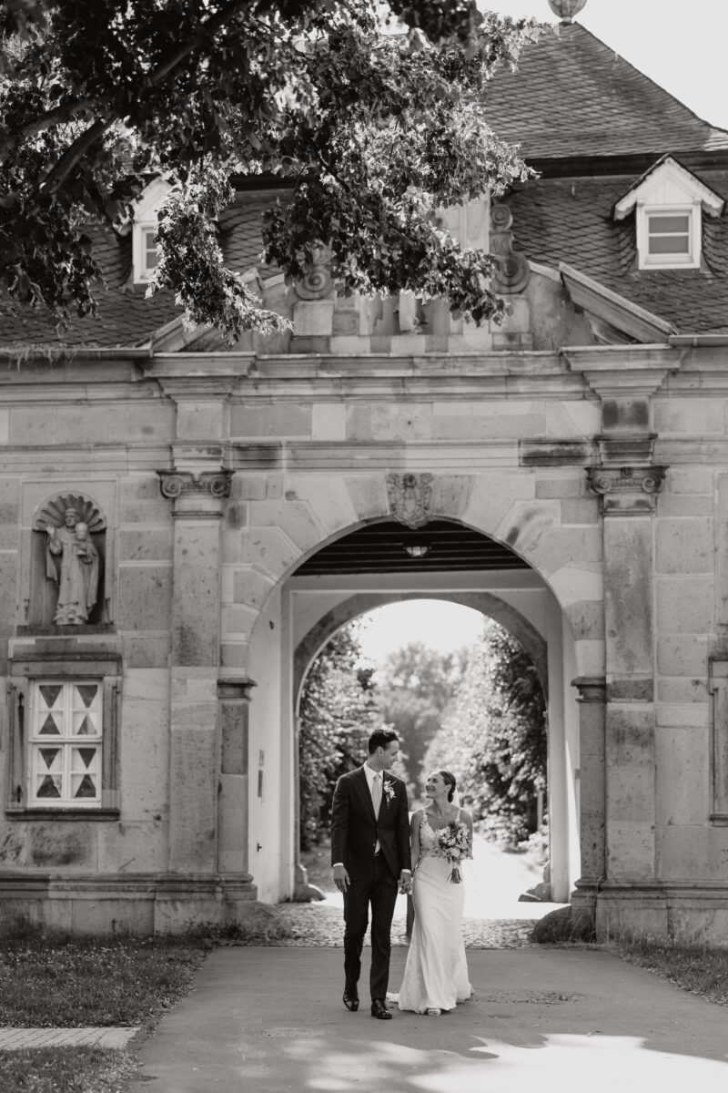 Hochzeitsportfolio, Brautpaar läuft Hand in Hand auf die Kamera zu und schauen sich dabei tief in die Augen