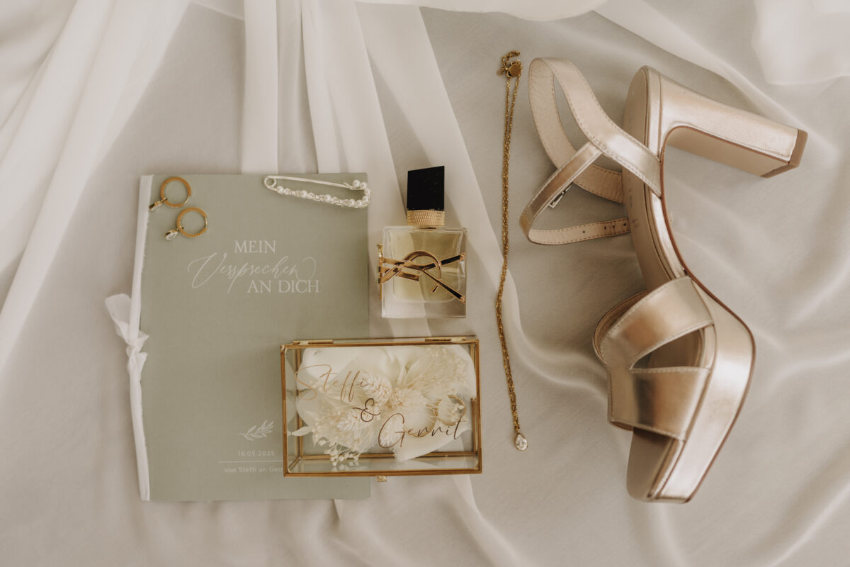 Hochzeitsportfolio, Flatlay vom Brautshuh, Parfum Ringe und Einladung