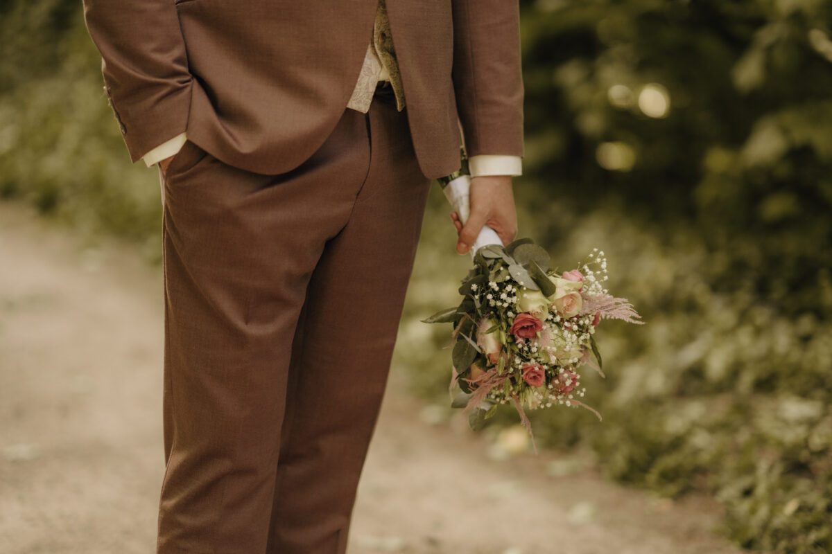 Hochzeitsportfolio, Detailaufnahme des Brautstraußes in der Hand des Bräutigams | Hochzeitsfotografin Köln
