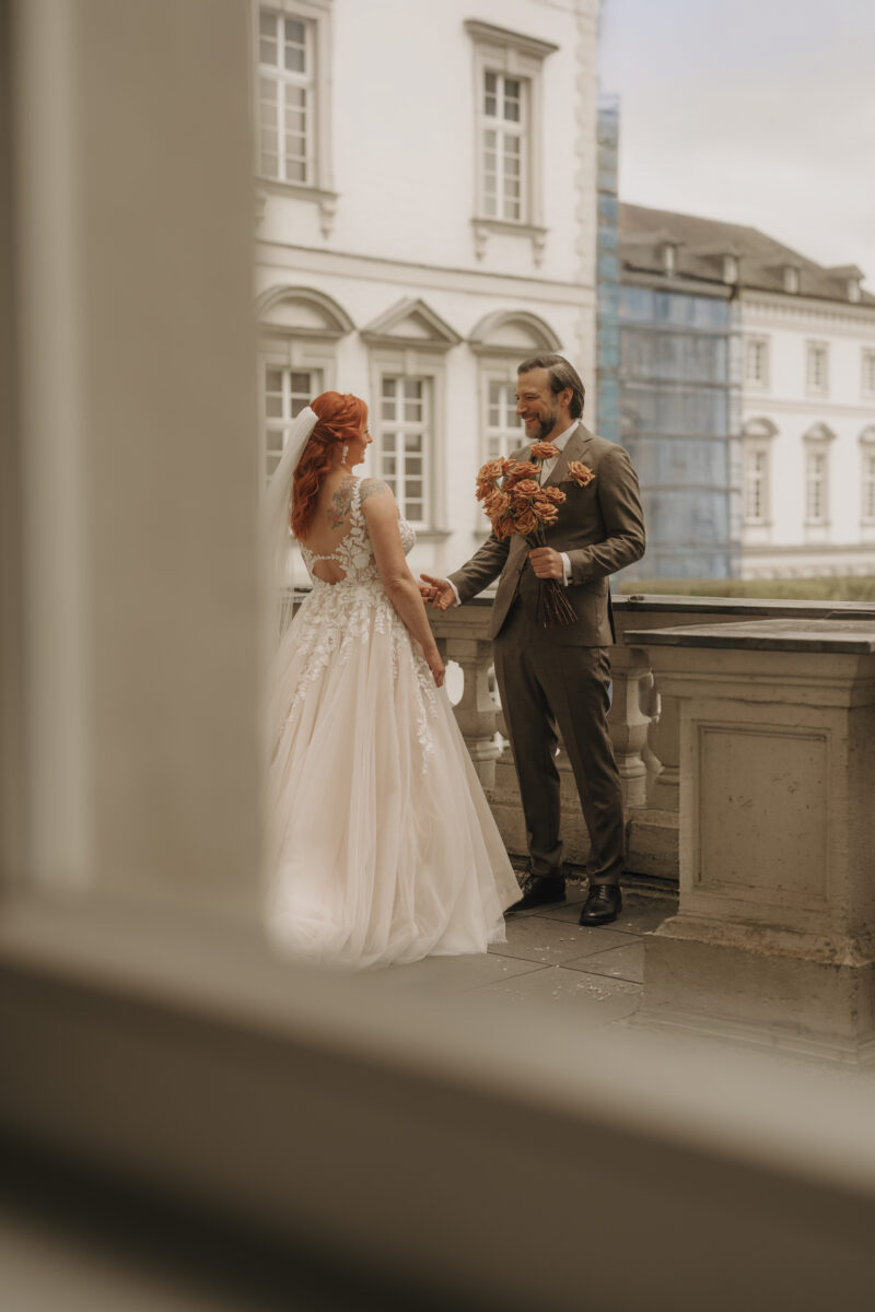 Hochzeitsportfolio, Brautpaar beim Paarshooting auf einem Balkon eines historischen Gebäudes | Hochzeitsreportage Köln
