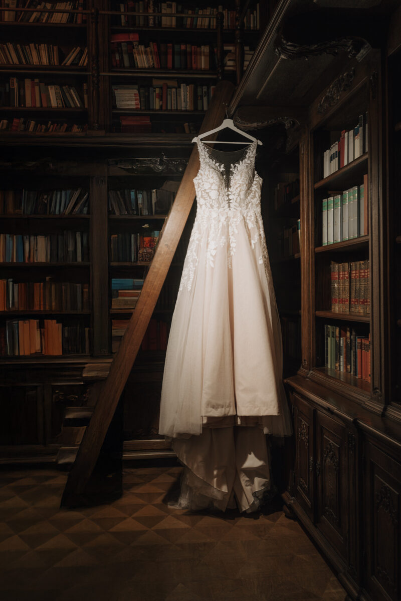 Hochzeitsportfolio, Brautkleid hängt elegant in einer Bibliothek vor der Hochzeit | Hochzeitsfotografie NRW